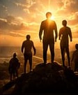 Silhouettes of men on a hilltop at sunrise